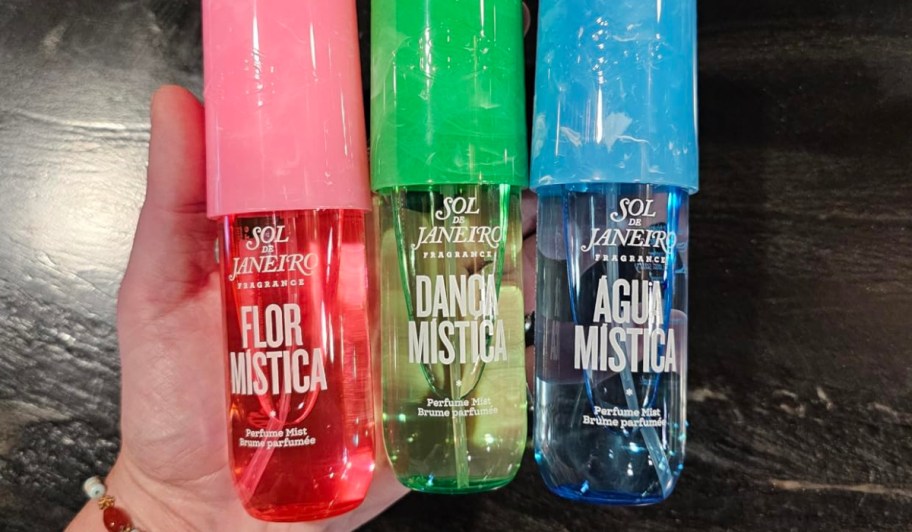 3 bottles of Sol de Janeiro Perfume in hand