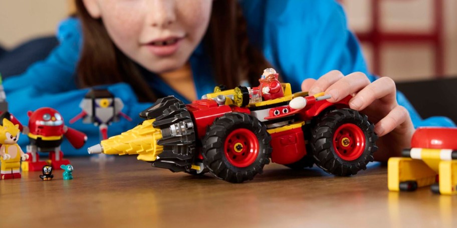 kid playing with red sonic lego set 