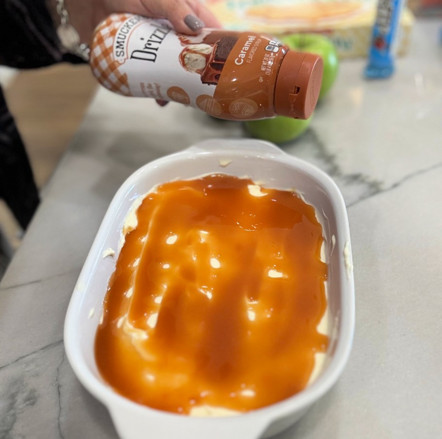 spreading caramel sauce on cheesecake filling