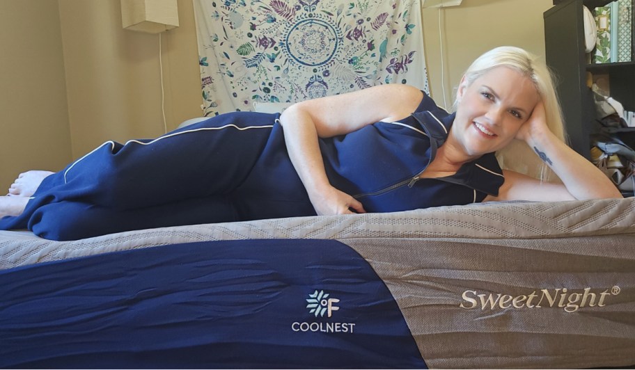 woman in navy silk pajamas laying on mattress