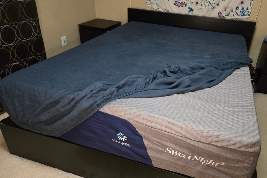 navy mattress with blue fitted sheet pulled back