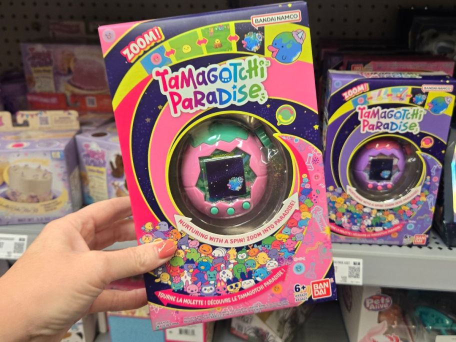 pink tamagotchi toy in hand in store