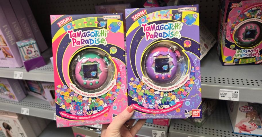 a pink and purple tamagotchi paradise toy in hand in store