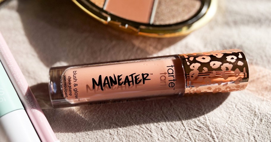 tube of tarte Maneater Blush & Glow Cheek Plump near other beauty products