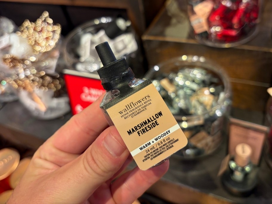 a hand holding a wallflowers scent plug refill