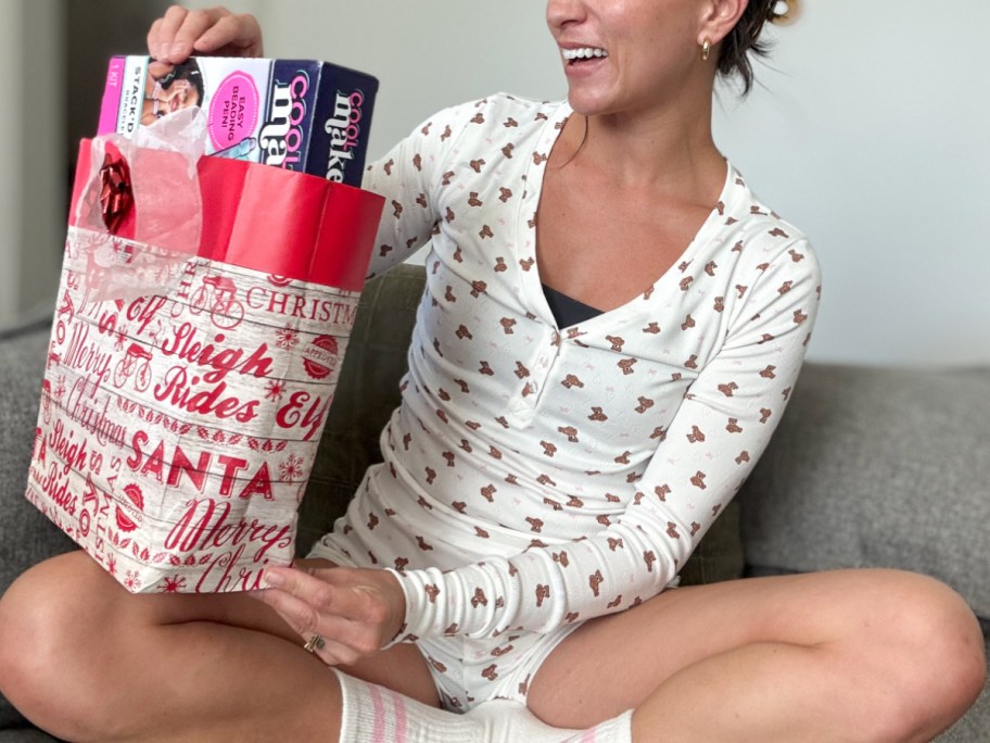 woman in teddy bear pajamas opening gift