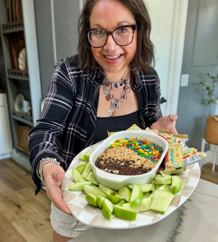 woman holding a caramel apple dip