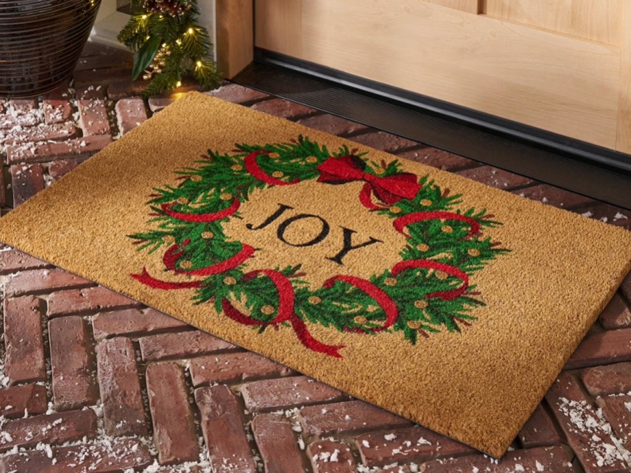 a Christmas coir doormat by a door