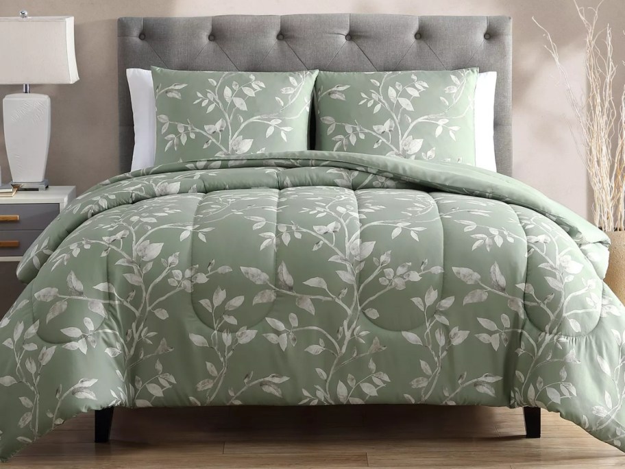 a green floral comforter set on a bed