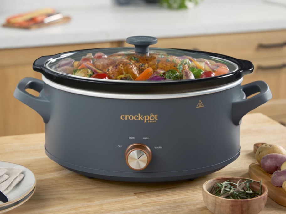 A gray crockpot with food in it.