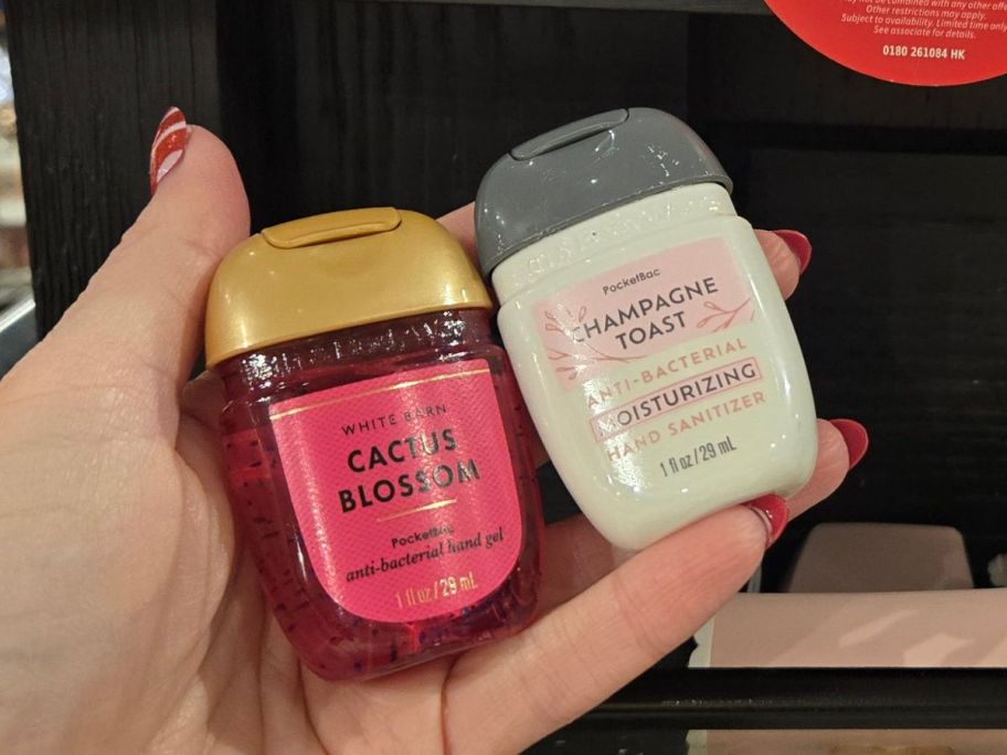 Hand holding two bath & Body Works Pocketbac Hand Sanitizers