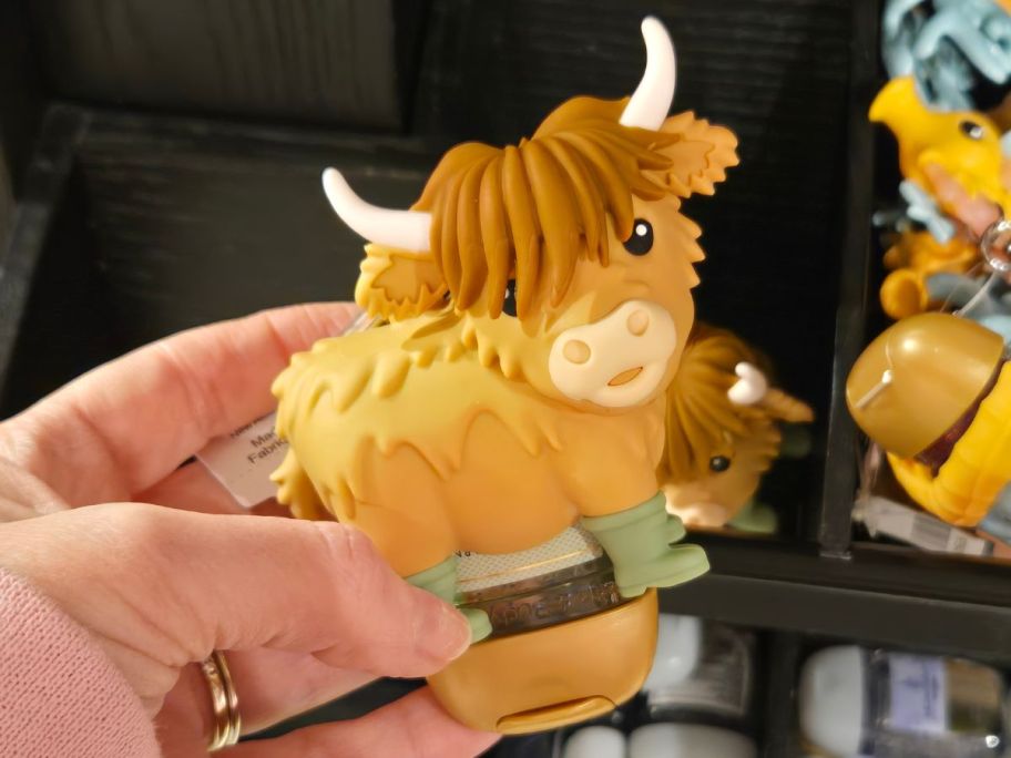 Hand holding a highland cow pocketbac