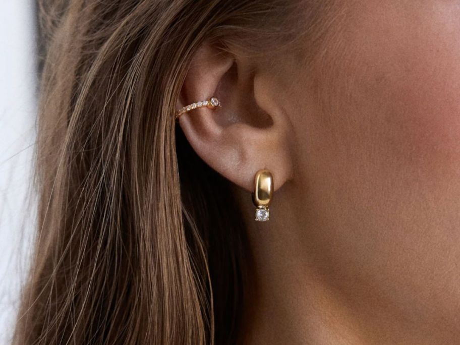 A woman wearing gold earrings 