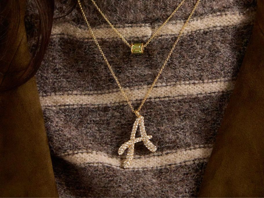 A woman wearing a gold initial "A" necklace 