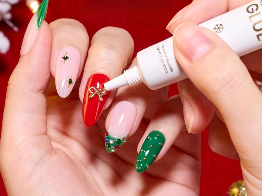 A person gluing a bow to their finger nails