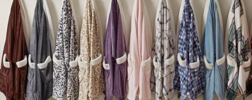 Macy's blanket wraps hanging on hooks on wall