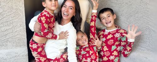 A family wearing Red Burt's Bees Matching Family Pajamas with Gingerbread Cookies on them