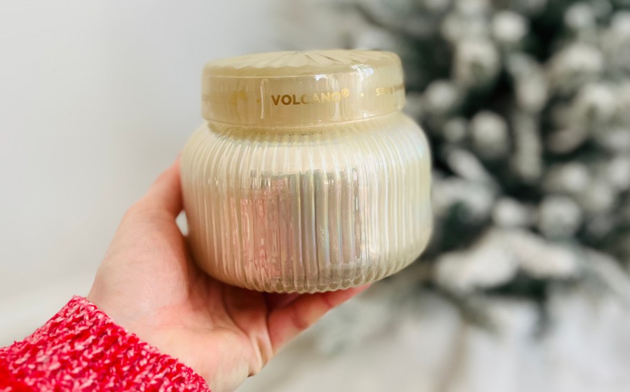 hand holding cream colored candle