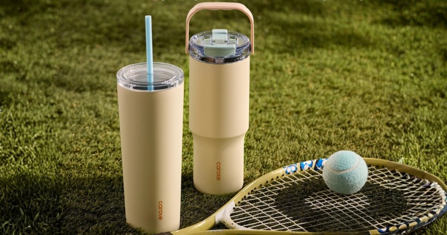 carote tumblers in yellow in two sizes on grass with tennis ball and racket