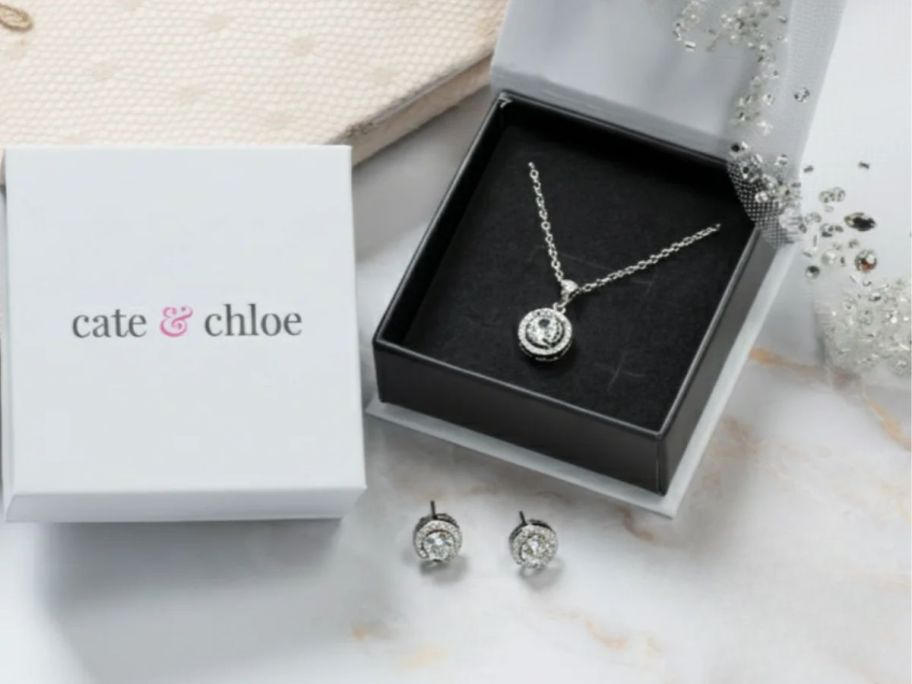 A necklace and earring set with a white box
