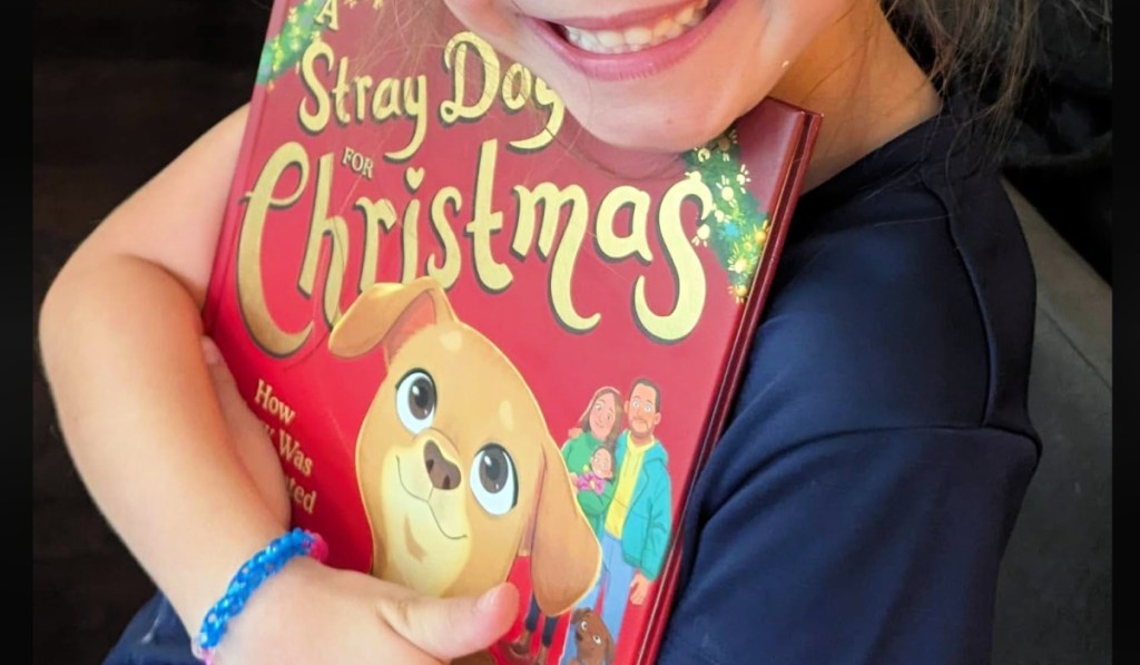 child holding A Stray Dog for Christmas Hardcover Book