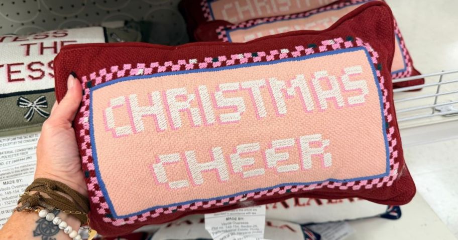 Christmas Cheer Cross Stitch Pillow in hand in store