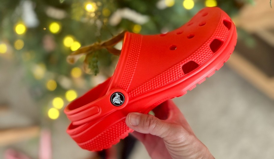 red crocs classic clogs in front of christmas tree