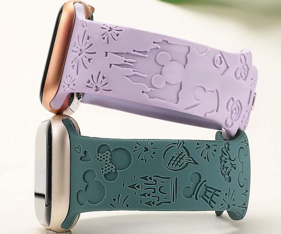 two watch bands (in purple and green) with Disney engravings on them 