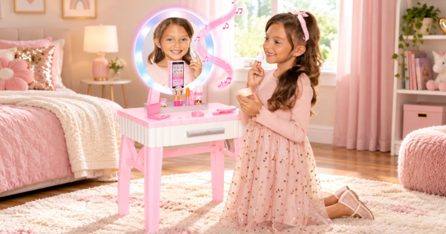 girl kneeling in front of a pink disney princess vanity