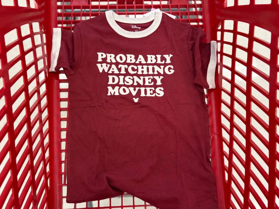 A Graphic Tee in a Target shoping cart that says Probably Watching Disney Movies on it