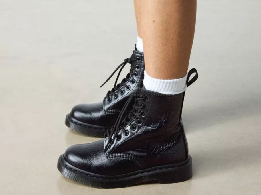 woman's feet wearing Dr. Martens 1460 Croco Embossed Boots