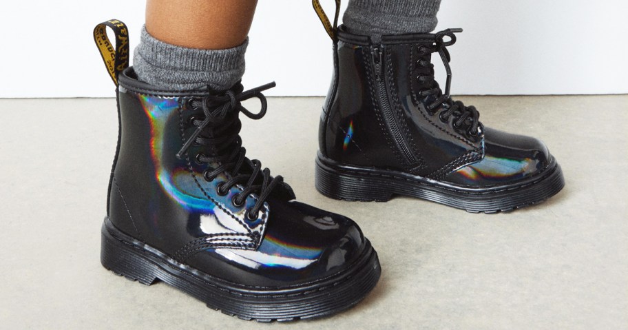child wearing black shiny rainbow lace up boots