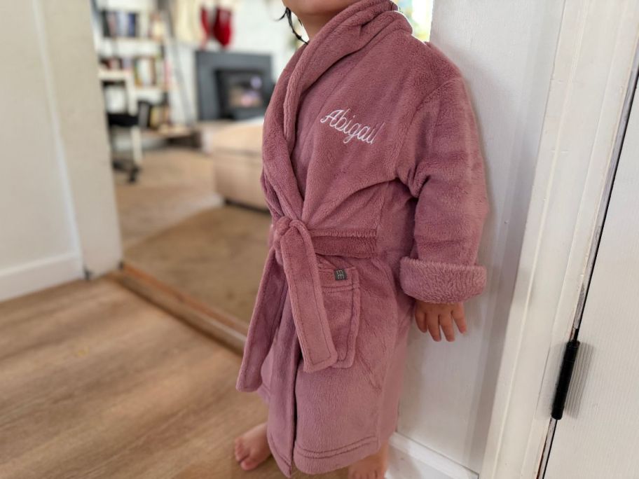 Little girl wearing a Gerber Pink robe with Abigail embroidered on it