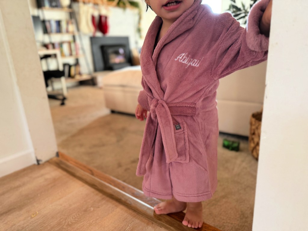 Toddler girl wearing purple Gerber bathrobe with her name embroidered in the top corner