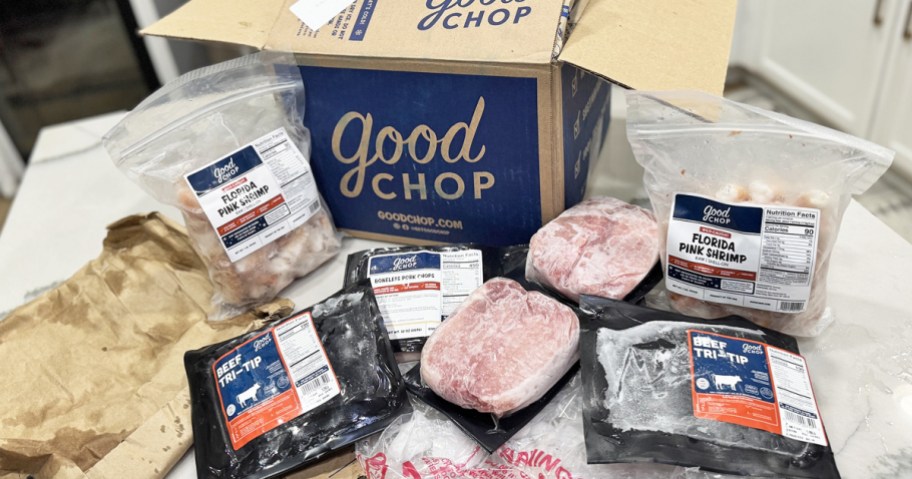 good chop shipping box on counter with various meats in front of it