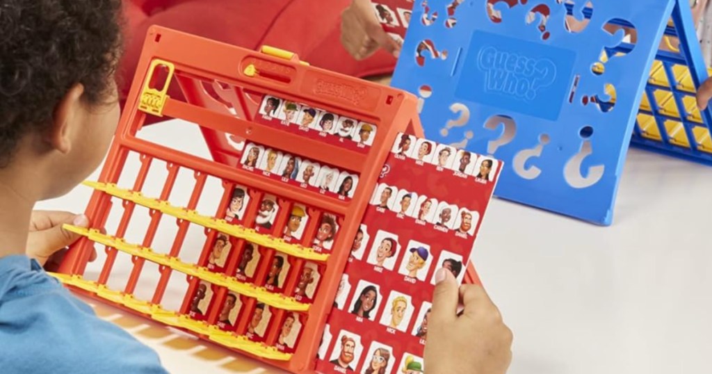 boy and girl playing guess who game at table