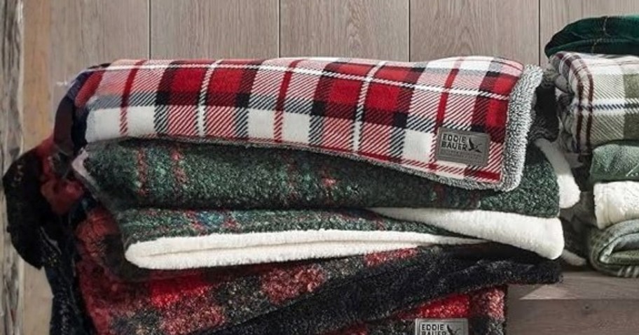 throw blankets stacked on a bench