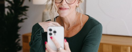 Collin (woman) looking at her smartphone and slightly smiling