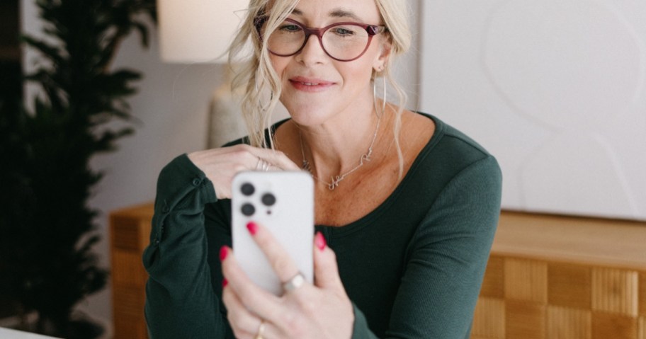 Collin (woman) looking at her smartphone and slightly smiling