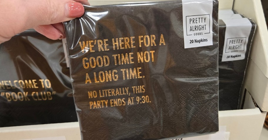 hand holding a pack of napkins that says "We're Here for a Good Time Not A Long Time"