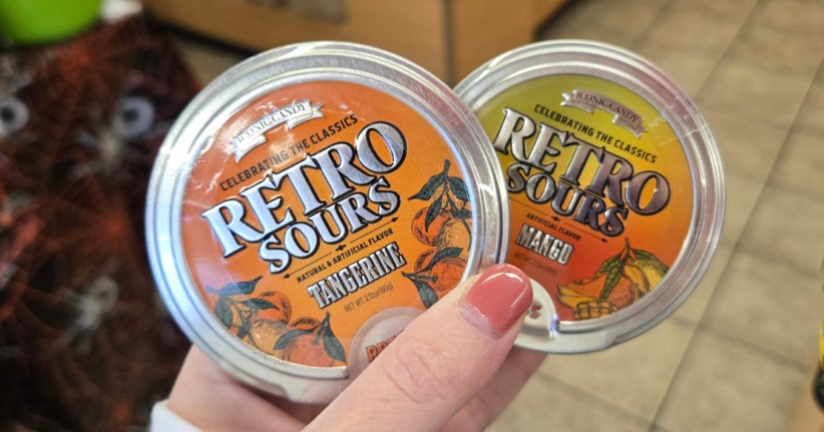 hand holding 2 cases of Retro Sours candy