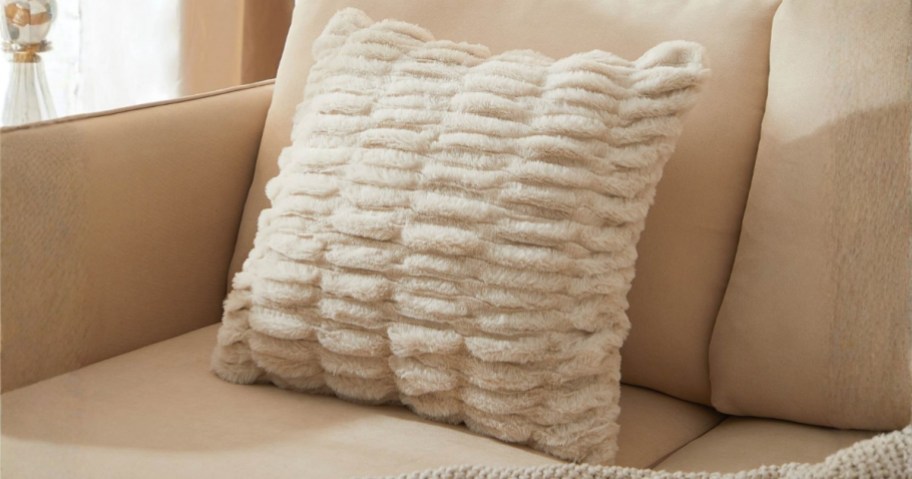 a decorative faux fur throw pillow on a sofa