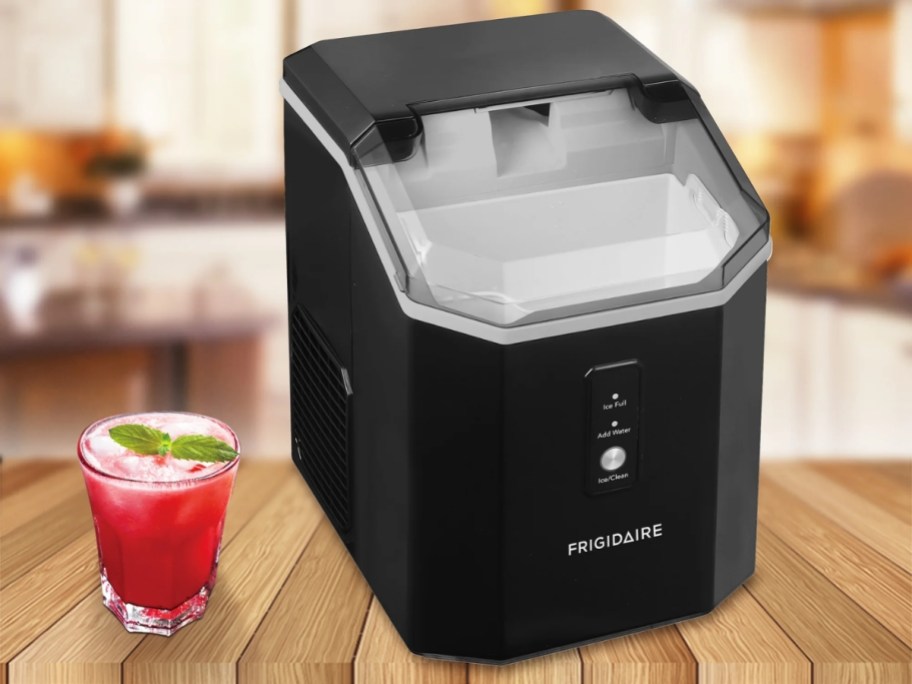 a black nuggest ice maker on a counter next to a drink