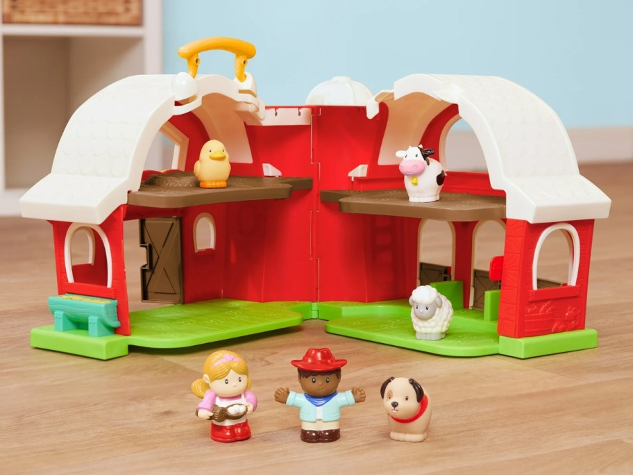 a toy barn playset open showing the inside and animals and farmers