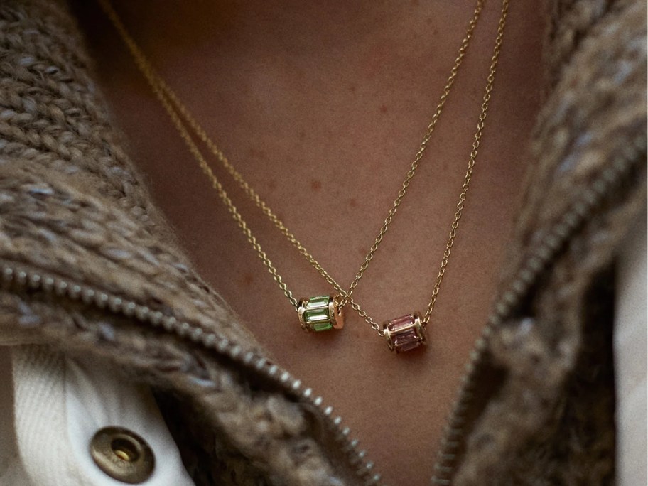 woman's neck/chest wearing two birthstone neckalces