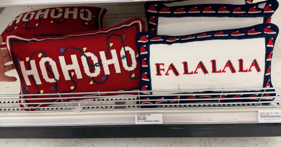 Ho Ho Ho and Fa La La La Cross Stitch Pillows on shelf in store