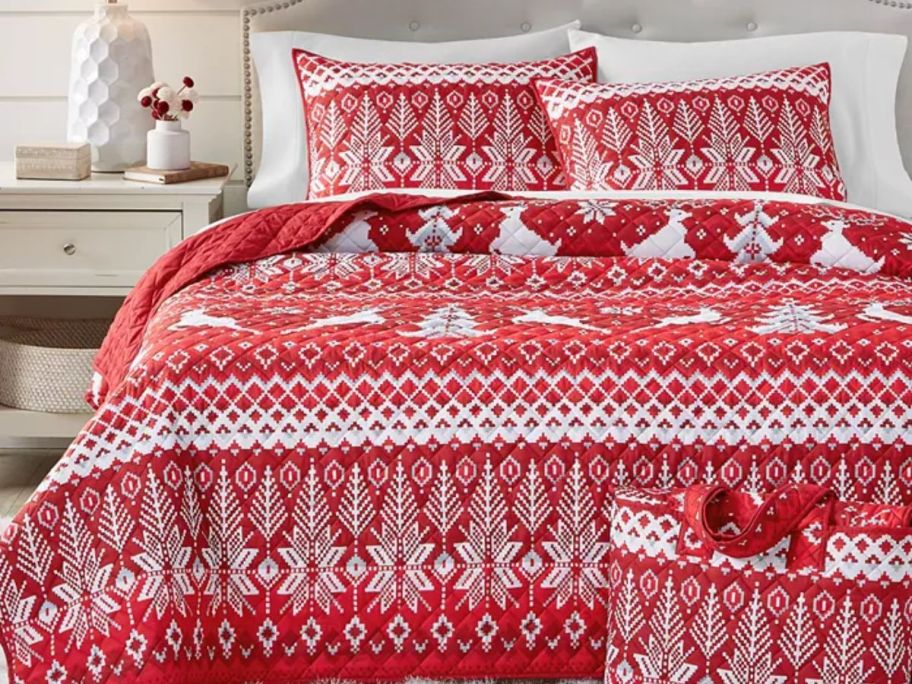 A red and white quilt on a bed