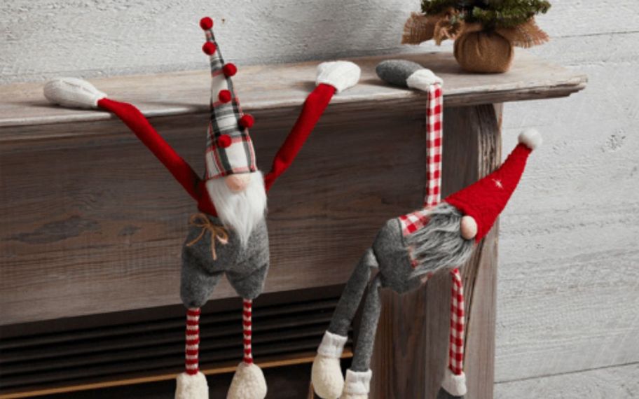 Two gnomes hanging from fireplace decor