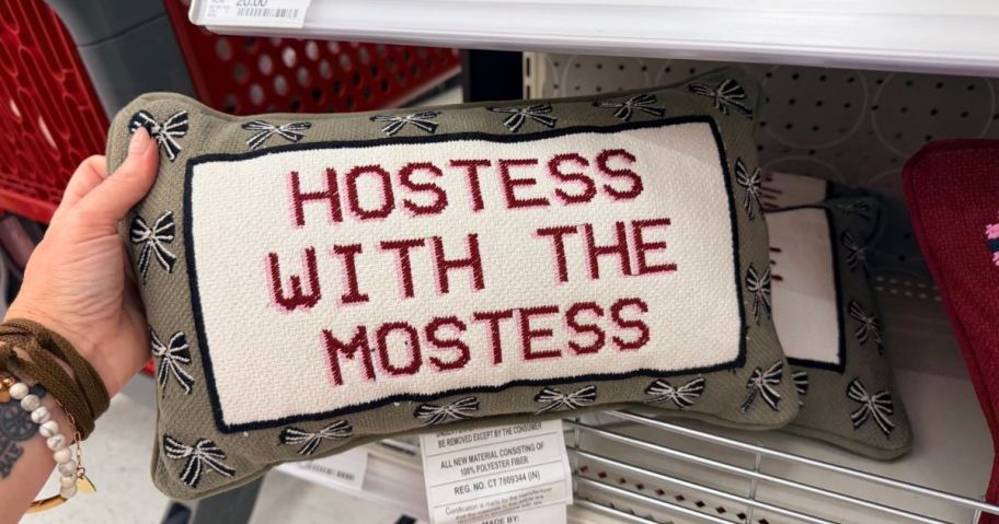 Hostess with the Mostess Cross Stitch Pillow in hand in store