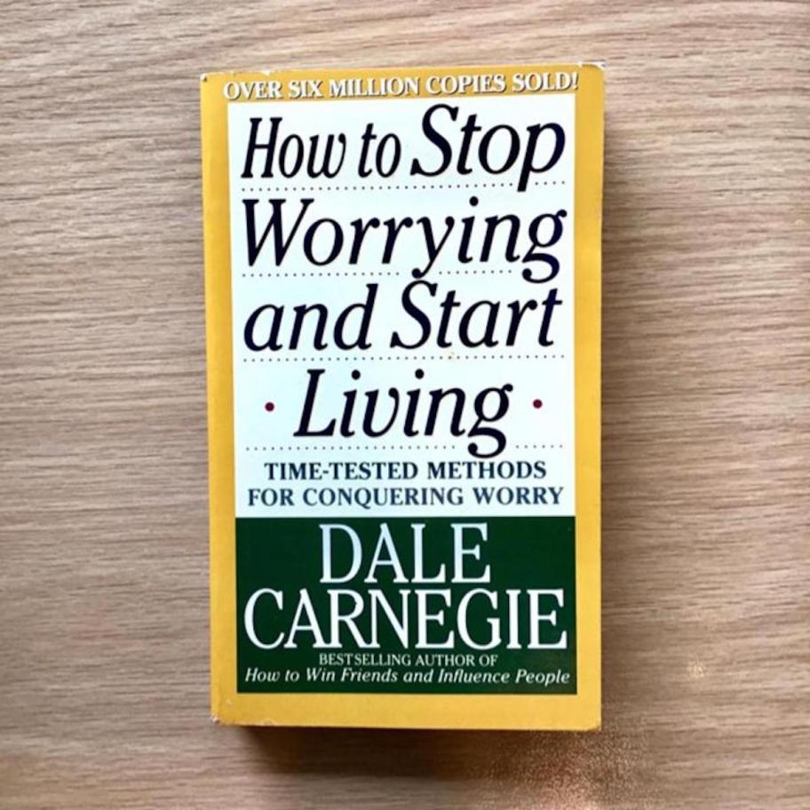 how to stop worrying and start living book on wood table